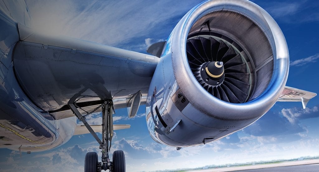 Closeup of a jet engine, blue sky and mare's tails in the background